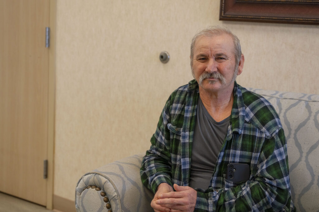 Resident Sitting on couch smiling at Kent County Nursing home in Jayton, TX